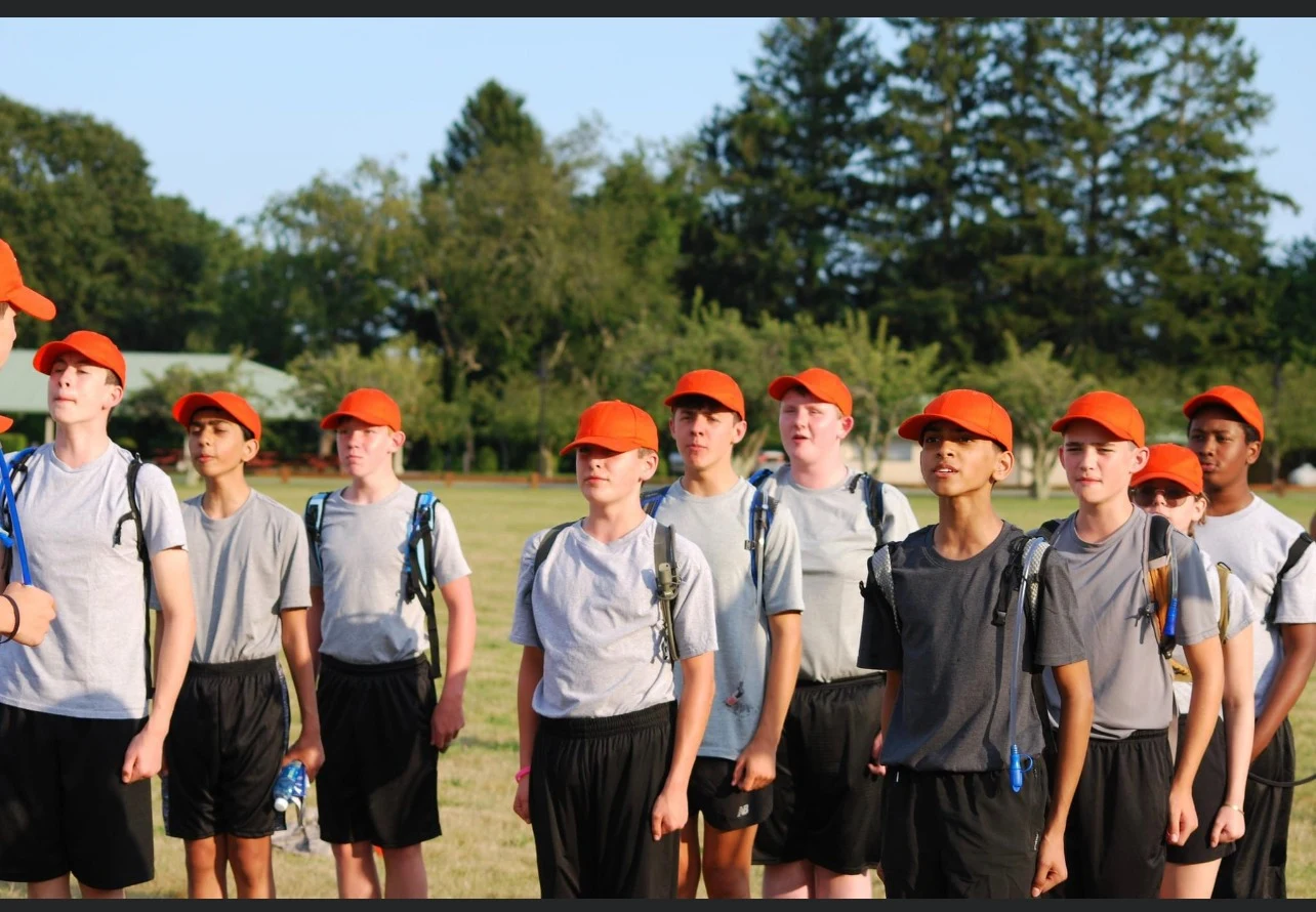 A group of cadets in orange caps during outdoor training